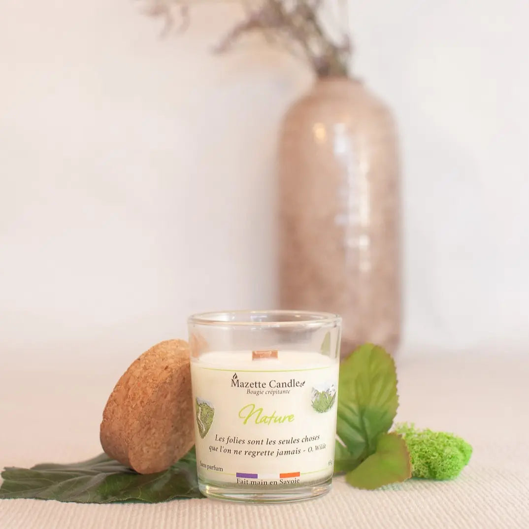 Bougie Mazette Candle Nature 65g sans parfum, avec couvercle en liège posé sur le côté, dans un décor végétal