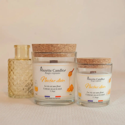 Deux bougies Mazette Candle Nectar divin 65g et 150g parfum miel, avec leurs couvercles en liège, et un petit vase en décor