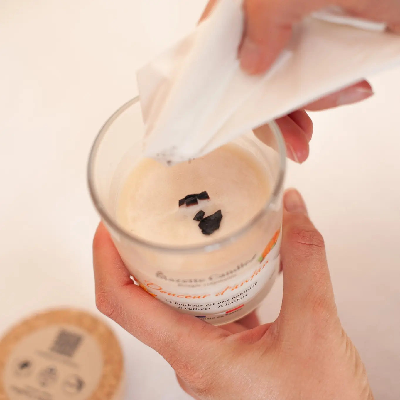 Entretien d’une bougie avec mèche en bois Mazette Candle : retrait des résidus de mèche carbonisés avec un mouchoir