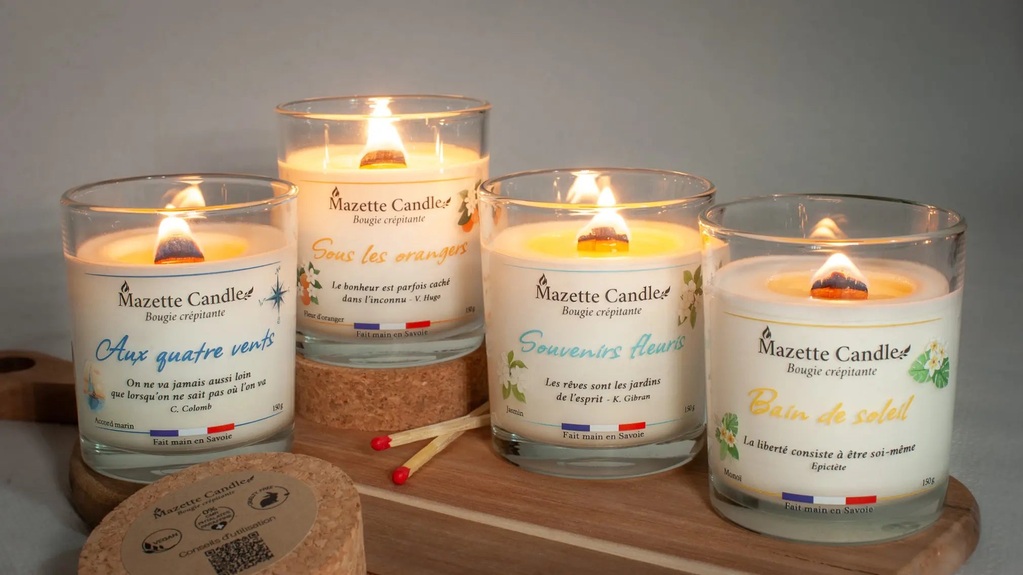 4 bougies Mazette Candle allumées, dont la flamme évoque le doux crépitement d'un feu de cheminée