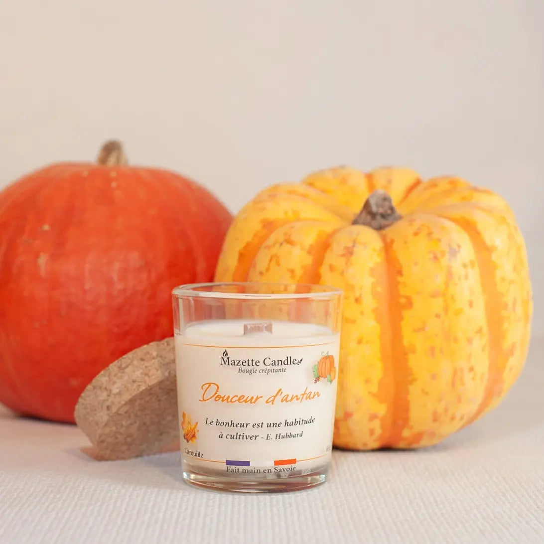 Bougie Mazette Candle Douceur d’antan 65g parfum citrouille, avec couvercle en liège posé à côté et deux citrouilles en décor